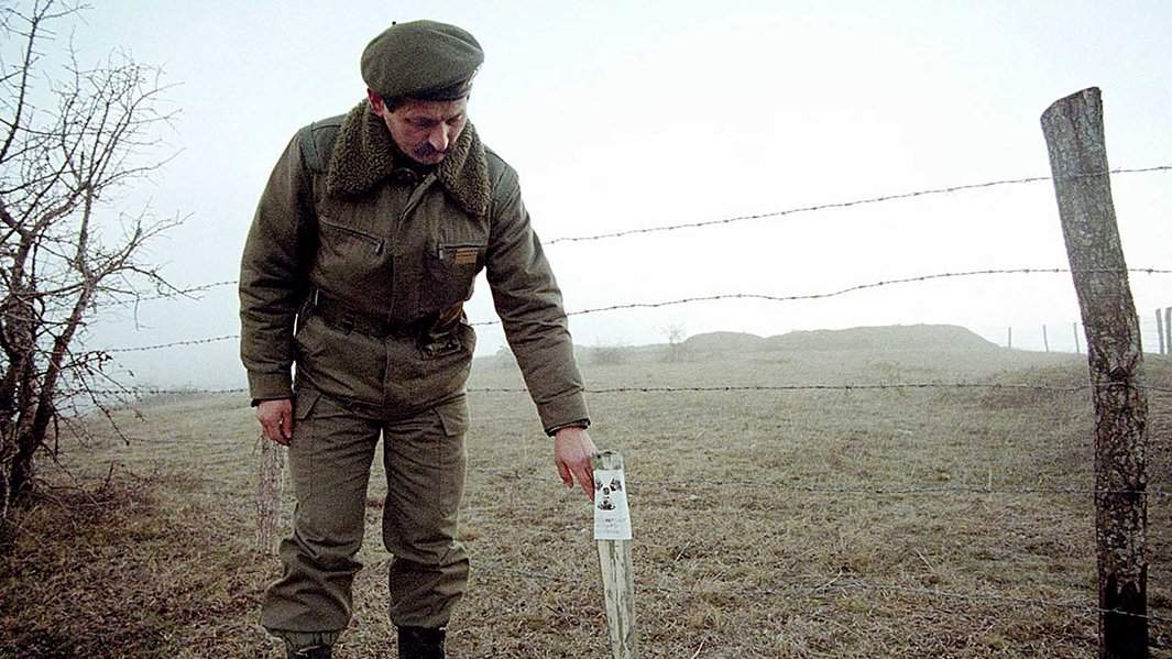 Офицер югославской армии показывает место, где военные обнаружили стреляные пули с обедненным ураном в деревне Релина, примерно в 7 км от южного сербского города Прешево, 7 января 2001 года