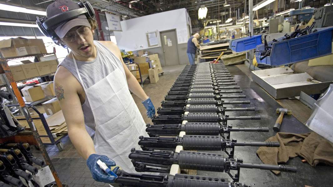 США — Сотрудник пулеметного завода Colt Defense собирает винтовку М-4
