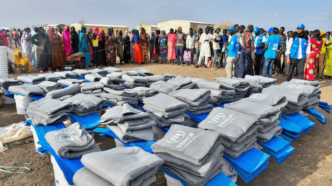 Гражданские лица, бежавшие из раздираемого войной Судана после начала боевых действий между суданской армией и военизированными Силами оперативной поддержки (RSF), собираются, чтобы получить предметы первой необходимости в транзитном центре Управления Верховного комиссара Организации Объединенных Наций по делам беженцев УВКБ
