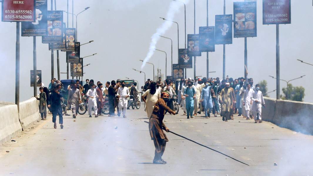 Сторонник бывшего премьер-министра Пакистана Имрана Хана бросает камни в полицию во время акции протеста против ареста Хана в Пешаваре Пакистан