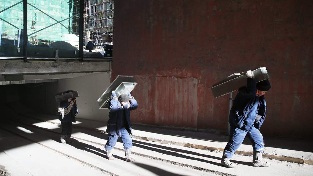 строители несут металлоконструкции