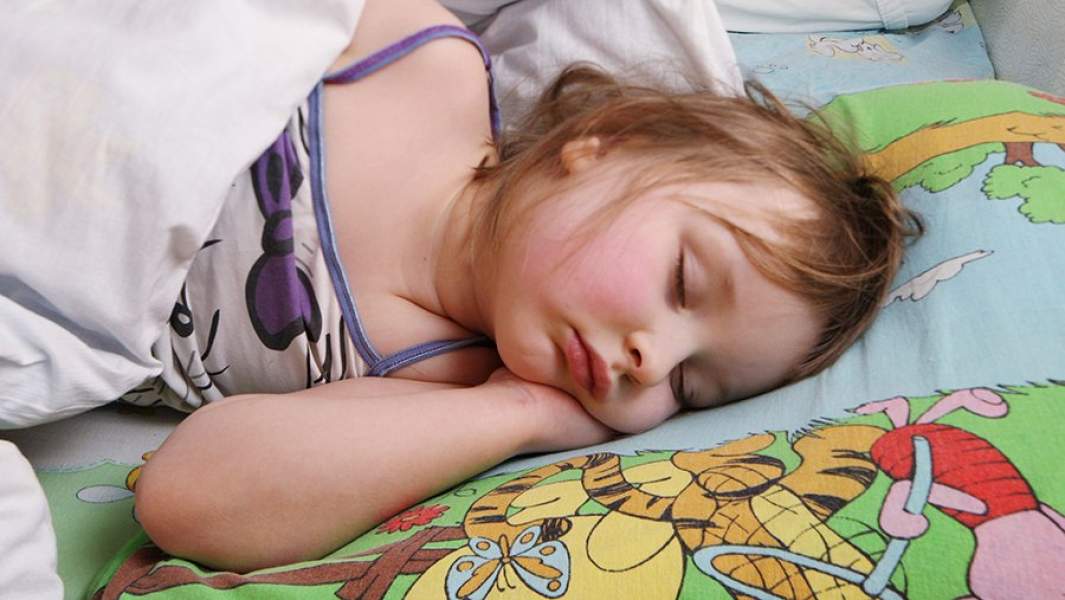 Девочка спит во время тихого часа в детском саду