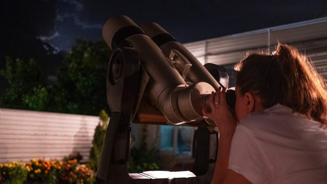 девушка смотрит в телескоп