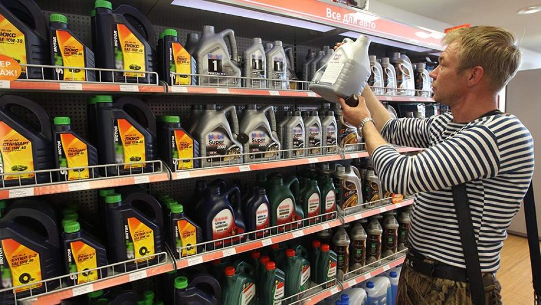 Мужчина рассматривает витрину с моторными маслами