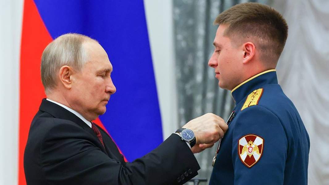 Владимир Путин и заместитель командира группы 33-го отдельного отряда специального назначения Центрального округа войск национальной гвардии РФ капитан Дмитрий Распутиков, награжденный орденом Мужества