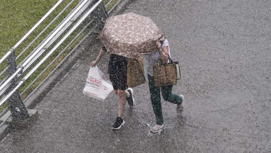 Люди под зонтом во время ливня