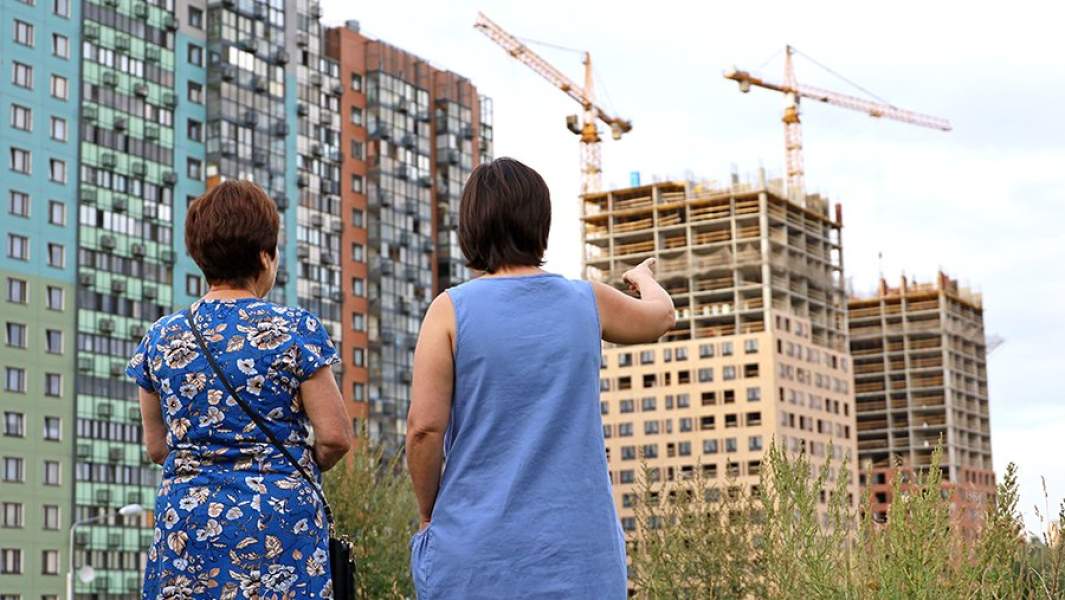 Покупатели квартир на фоне строящихся зданий жилого комплекса