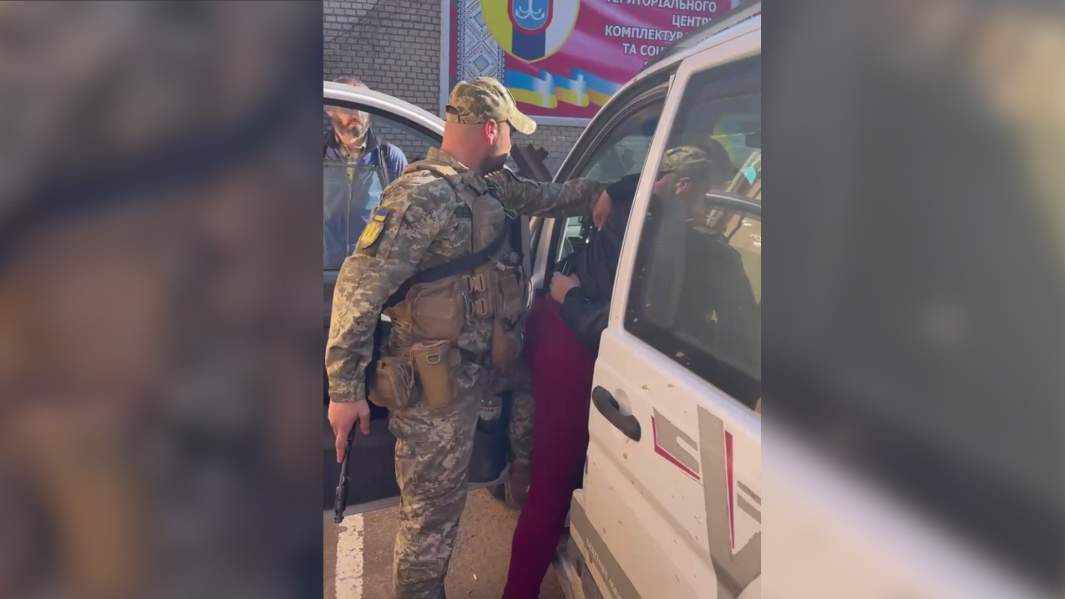 Сотрудники военкомата вытаскивают из машины мужчину на улице в Днепре