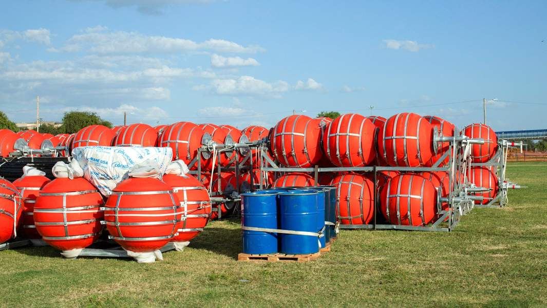 Оранжевые буи, сложенные рядом с берегом реки Рио-Гранде в Игл-Пасс в штате Техас