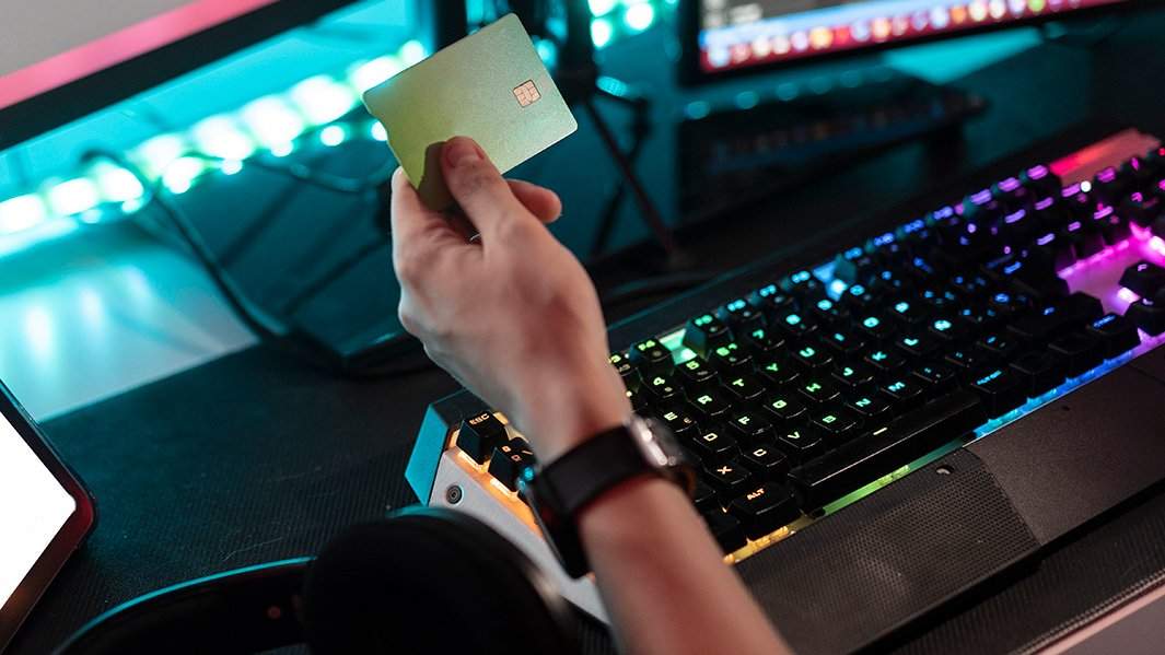 Геймер держит банковскую карту