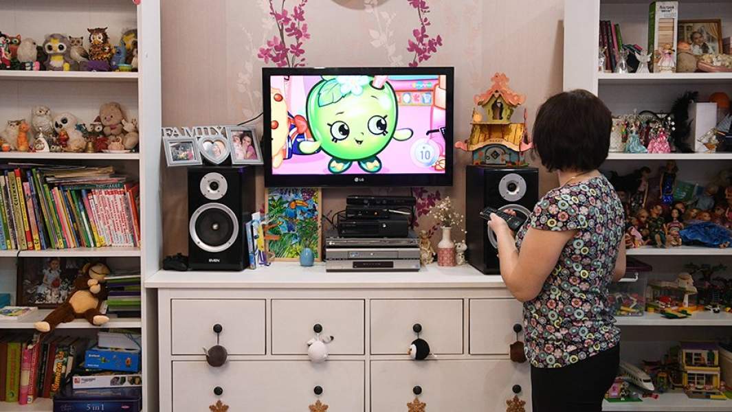 Женщина включает телевизор