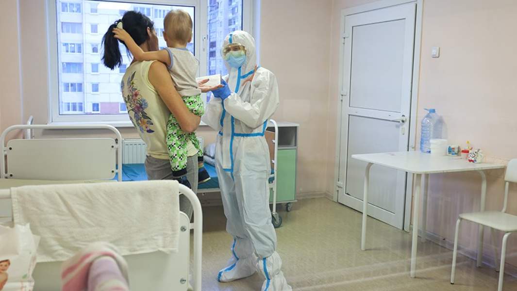 Медработник и пациентка с ребенком в красной зоне детской городской клинической больницы
