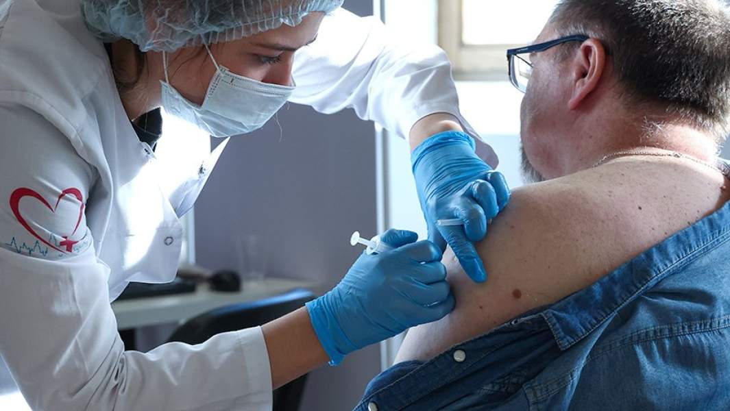 Медицинский сотрудник и пациент во время вакцинации от коронавирусной инфекции