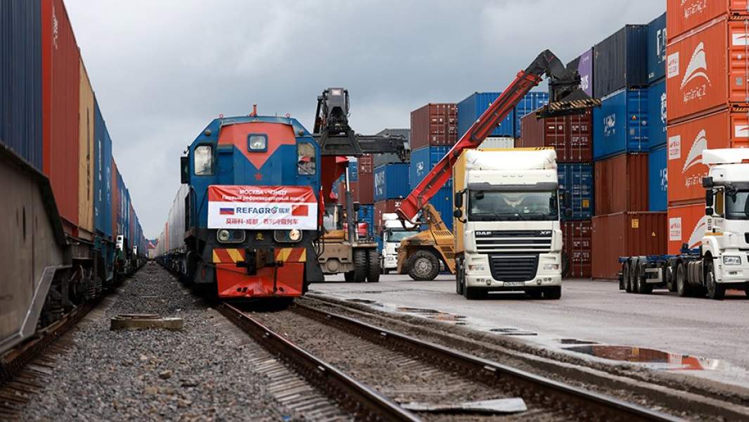 Погрузка контейнера на платформу грузовика-контейнеровоза на станции Селятино у рефрижераторного товарного поезда с агропродукцией, который отправляется в Китай по прямому сухопутному транспортному коридору