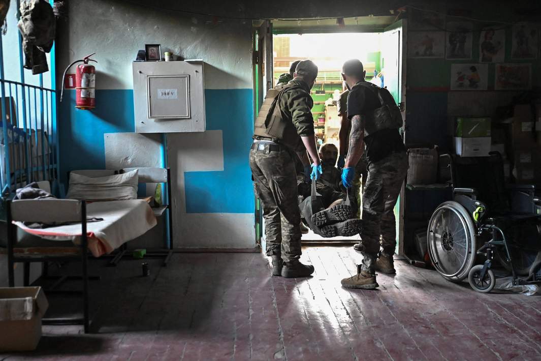 Медики несут раненого украинского военнослужащего в прифронтовой медпункт