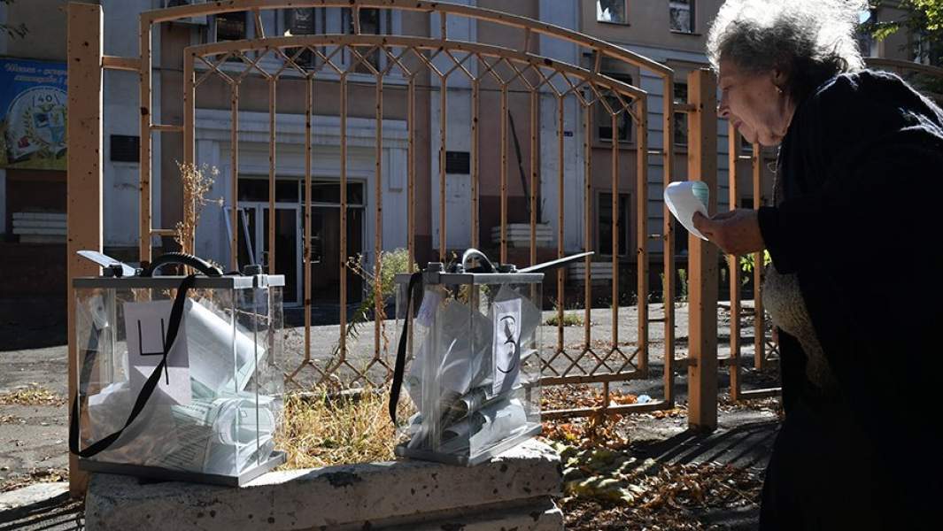 Женщина голосует на выездном избирательном участке