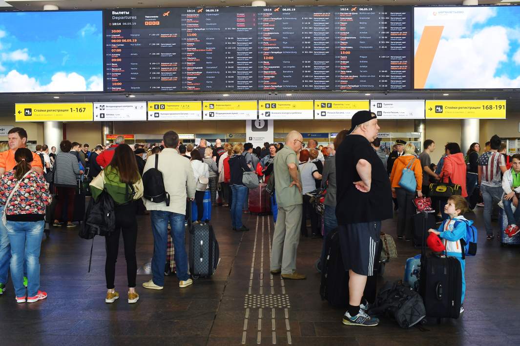 Пассажиры у табло рейсов в аэропорту Шереметьево