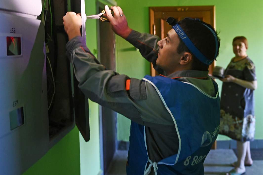 Сотрудник проводит работы по замене счетчиков учета электроэнергии в одном из жилых домов