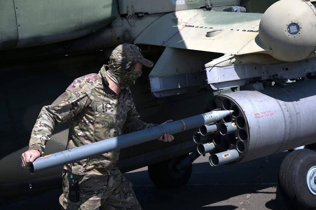 Технический персонал производит зарядку неуправляемых ракет в вертолет Ми-28 в зоне специальной военной операции