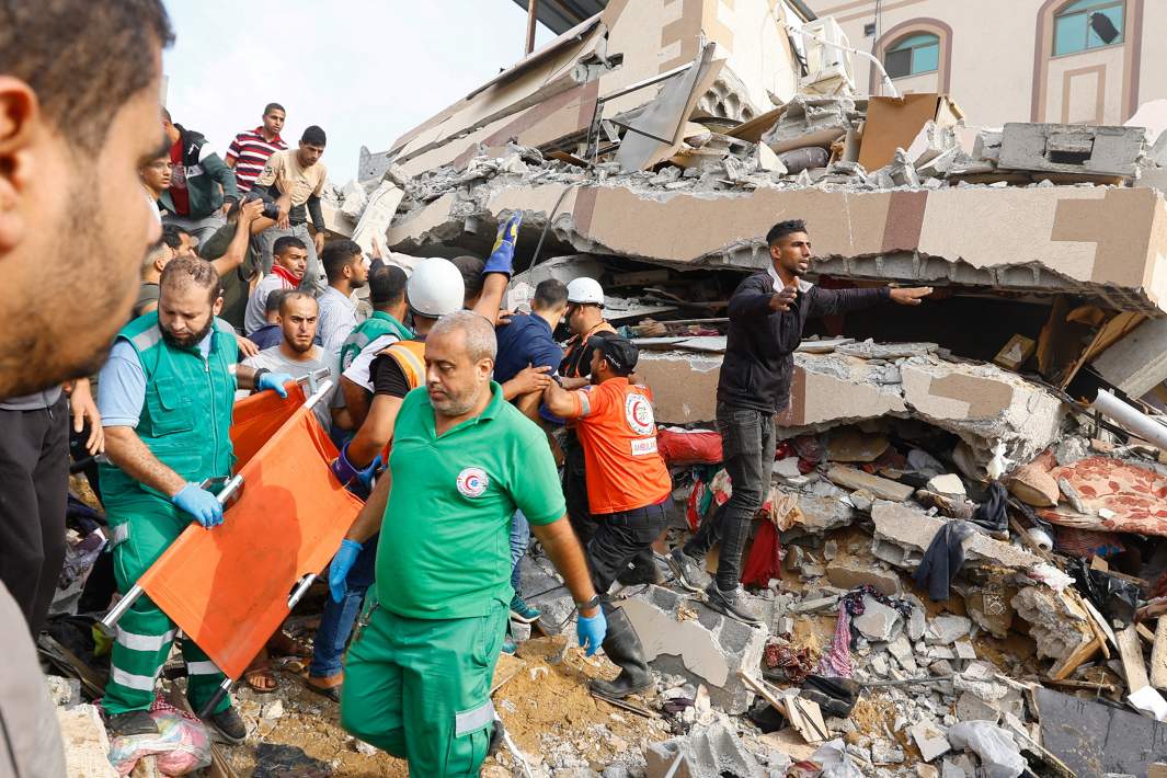Палестинцы обыскивают развалины дома, разрушенного в результате израильских ударов в Хан-Юнисе на юге сектора Газа, в поисках выживших
