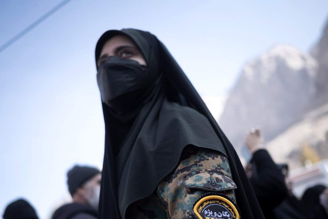 Женщина-сотрудница иранского полицейского спецназа наблюдает за территорией во время поминальной церемонии по бывшему отряду «Кудс» Корпуса стражей исламской революции (КСИР)