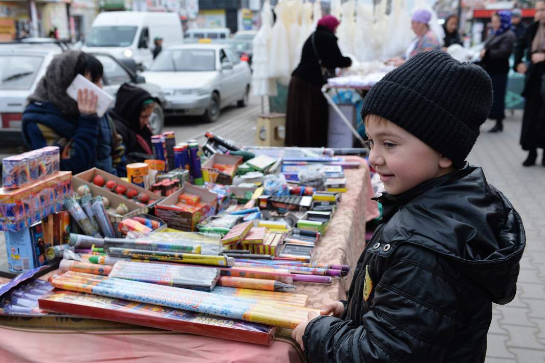 Мальчик разглядывает петарды на новогодней ярмарке