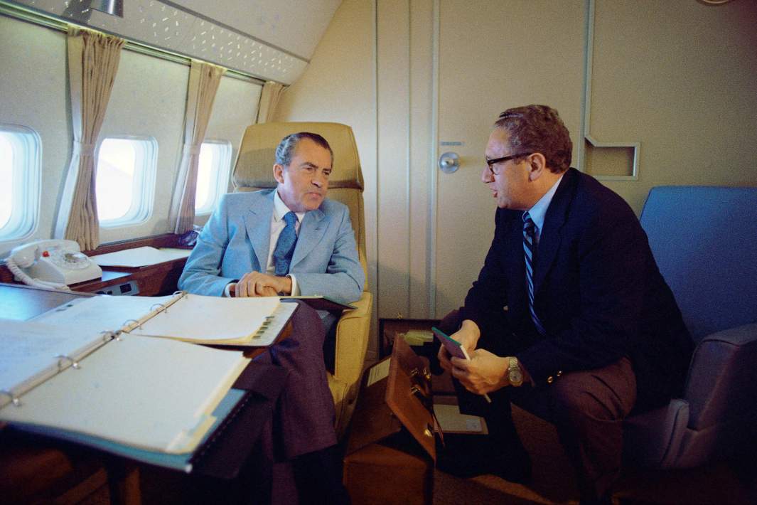 Президент США Ричард Никсон и советник по национальной безопасности Генри Киссинджер разговаривают на самолете Air Force One во время полета в Китай 20 февраля 1972 года