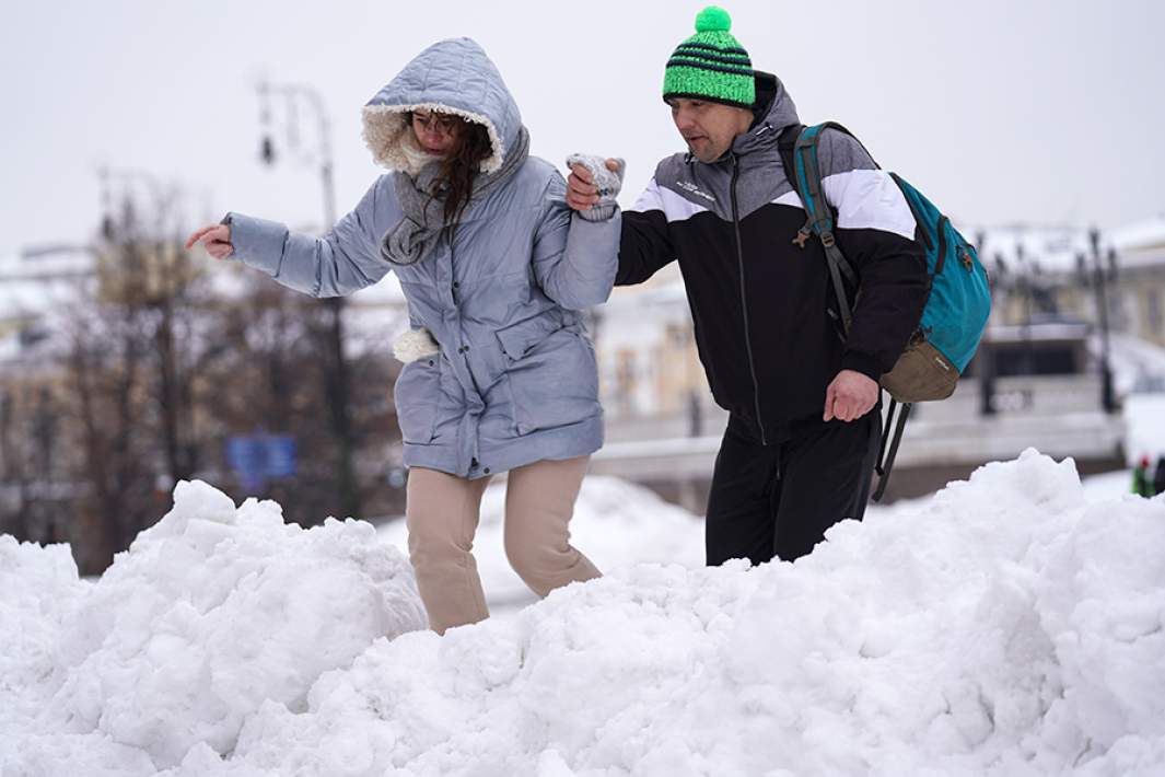 Прохожие на Красной площади в Москве после сильного снегопада