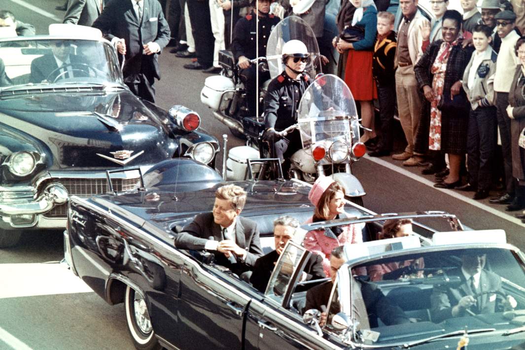 Джон Кеннеди, первая леди Жаклин Кеннеди, губернатор Техаса Джон Конналли и другие улыбаются толпе, выстроившейся вдоль маршрута кортежа в Далласе, штат Техас, 22 ноября 1963 года