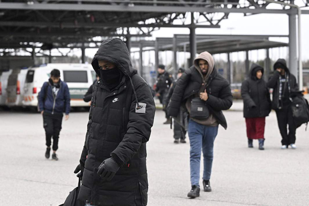 Лица, ищущие временного убежища, садятся в автобус, следующий в центр приема Йоутсено на границе между Россией и Финляндией