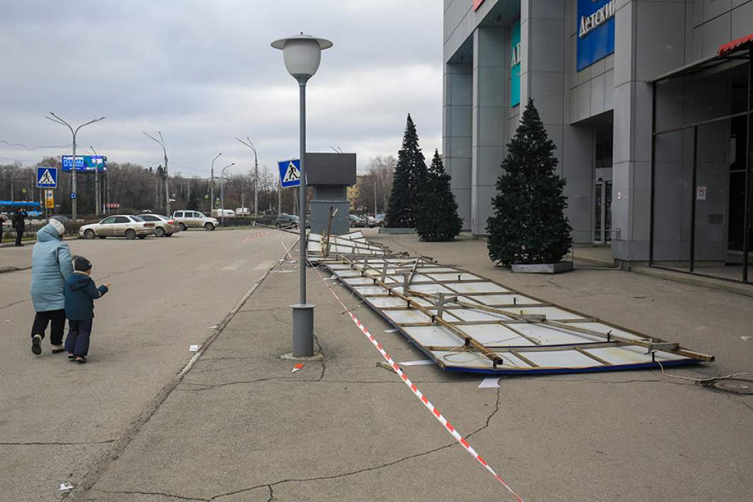 Вывеска, сорванная в результате сильного ветра, у торгово-развлекательного центра «Сити молл» в Новокузнецке. В результате пострадала женщина
