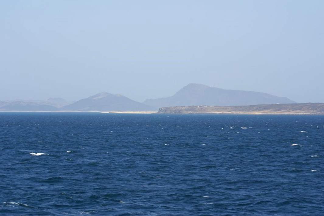 На фотографии изображена северная часть острова Перим в Баб-эль-Мандебском проливе на фоне гор полуострова Шейх-Саид (Йемен)