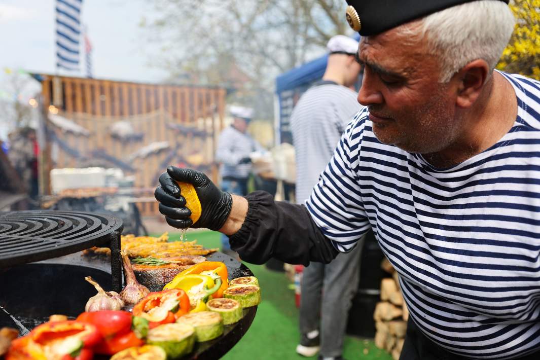 Мужчина готовит на гастрономическом фестивале «Фиштиваль» в Зеленоградске