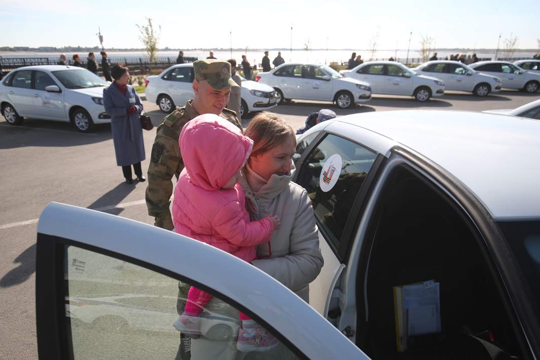 Военный с семьей у нового автомобиля Lada, переданного участникам СВО и ветеранам боевых действий, в Волгограде