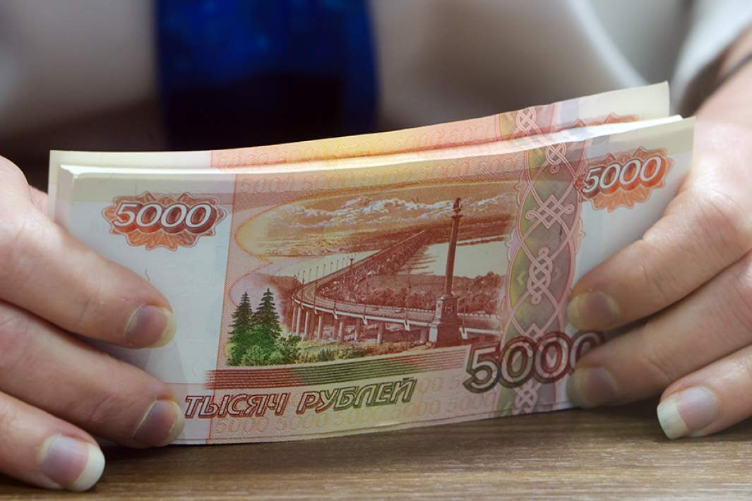 Банкноты номиналом 5000 российских рублей в руках кассира банка