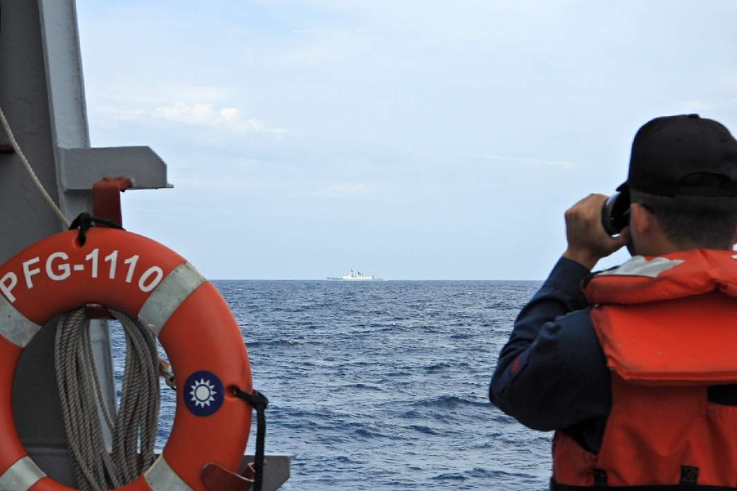 Солдат на борту фрегата «Тянь Дань» наблюдает за китайским фрегатом «Сюйчжоу» во время как китайских военных учений у границ Тайваня, август 2023 года