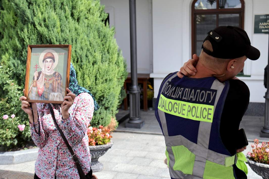 Полицейский рядом с прихожанкой Киево-Печерской лавры