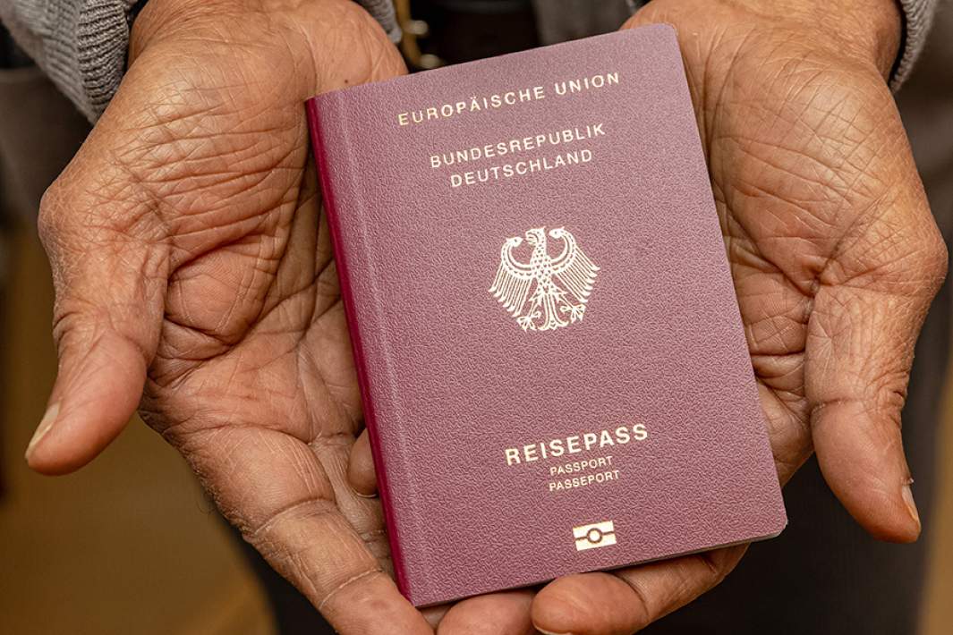 Паспорт ФРГ в руках мужчины