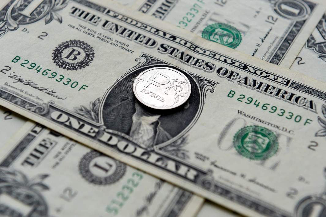 Купюры доллара и монета рубль