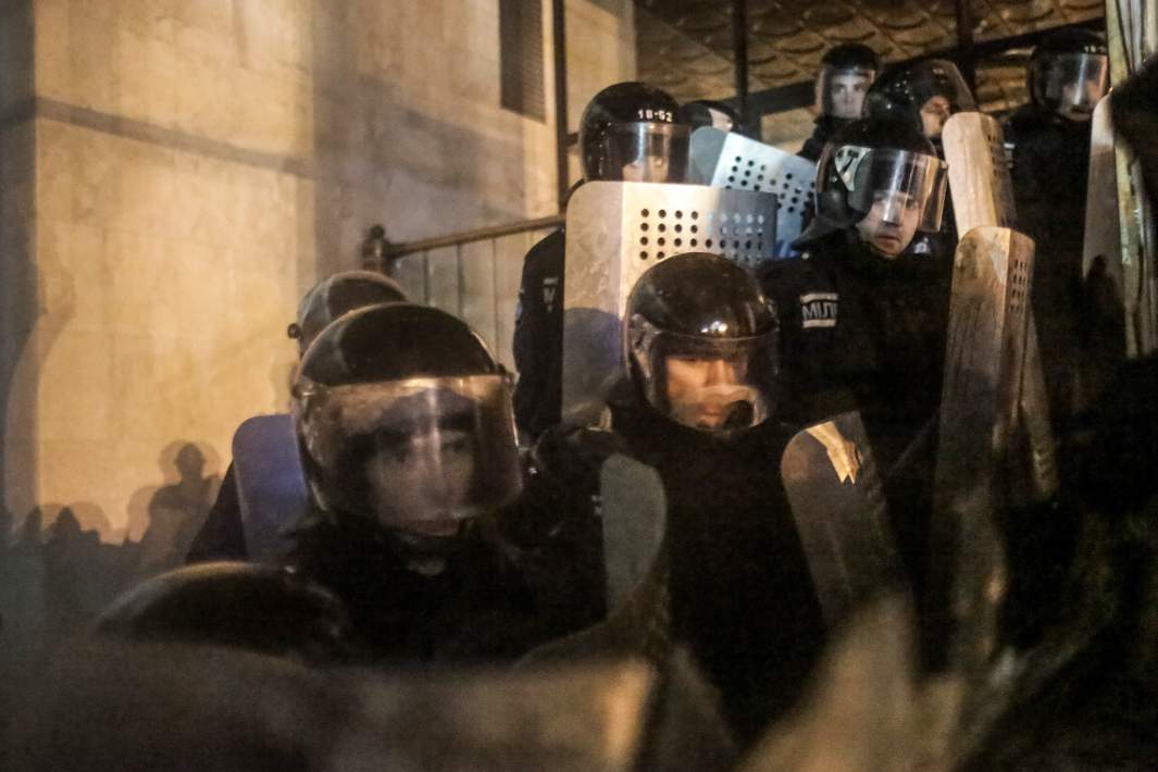 Сотрудники правоохранительных органов стоят в оцеплении у здания Украинского дома в центре Киева, 26 января 2014 года