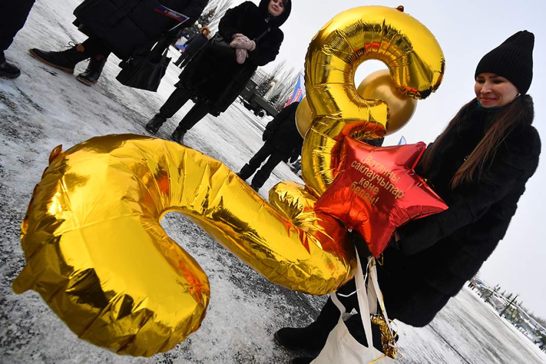 Воздушные шары в форме цифры 23 в руках девушки на патриотическом празднике ко Дню защитника Отечества в Парке Победы в Казани. 22 февраля 2023 года