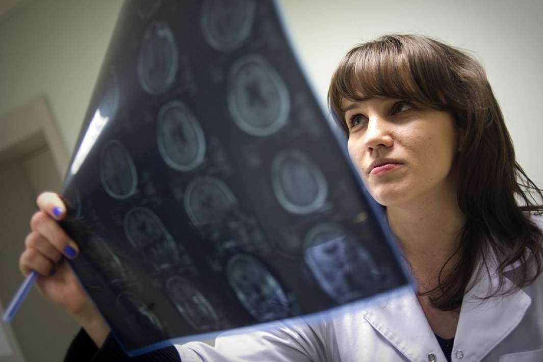 Врач клиники изучает результаты магнитно-резонансной томографии мозга