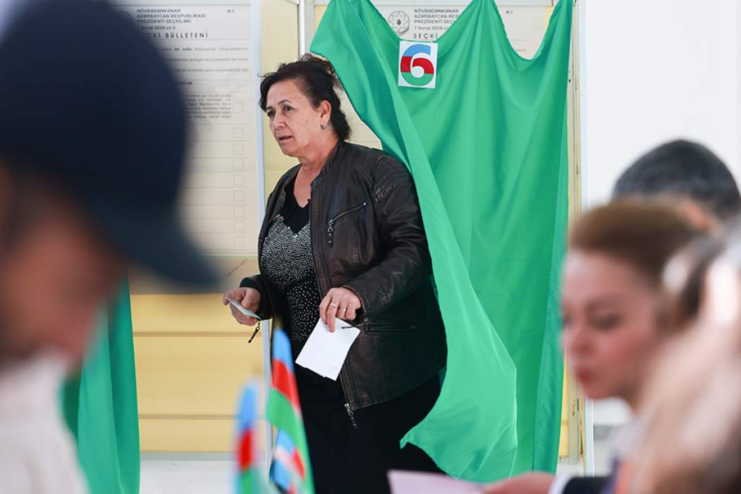 Женщина с бюллетенем во время голосования на внеочередных президентских выборах на избирательном участке