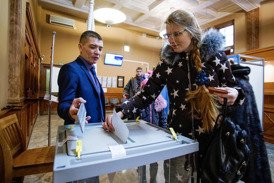 Девушка голосует на выборах президента РФ на территории российского консульского отдела в Риге