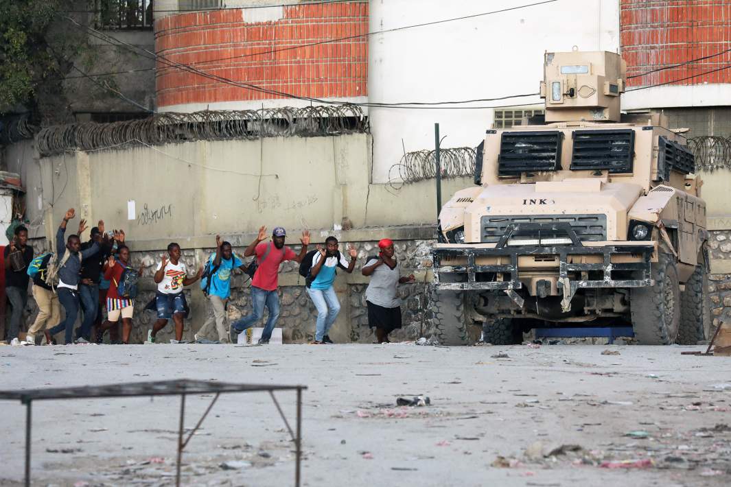 Люди уходят из района, где полиция противостоит вооруженным бандам после того, как известный лидер банды Джимми Шеризье призвал к свержению правительства премьер-министра Гаити Ариэля Генри, в Порт-о-Пренсе, Гаити, 29 февраля 2024 года