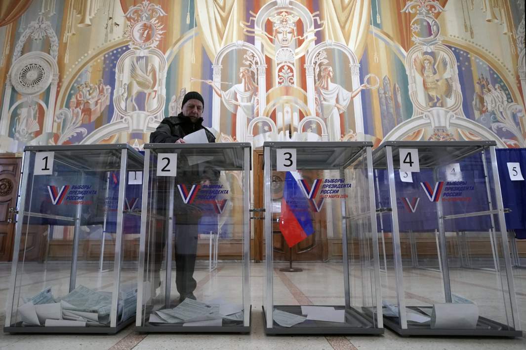 Мужчина голосует на выборах президента России на одном из избирательных участков