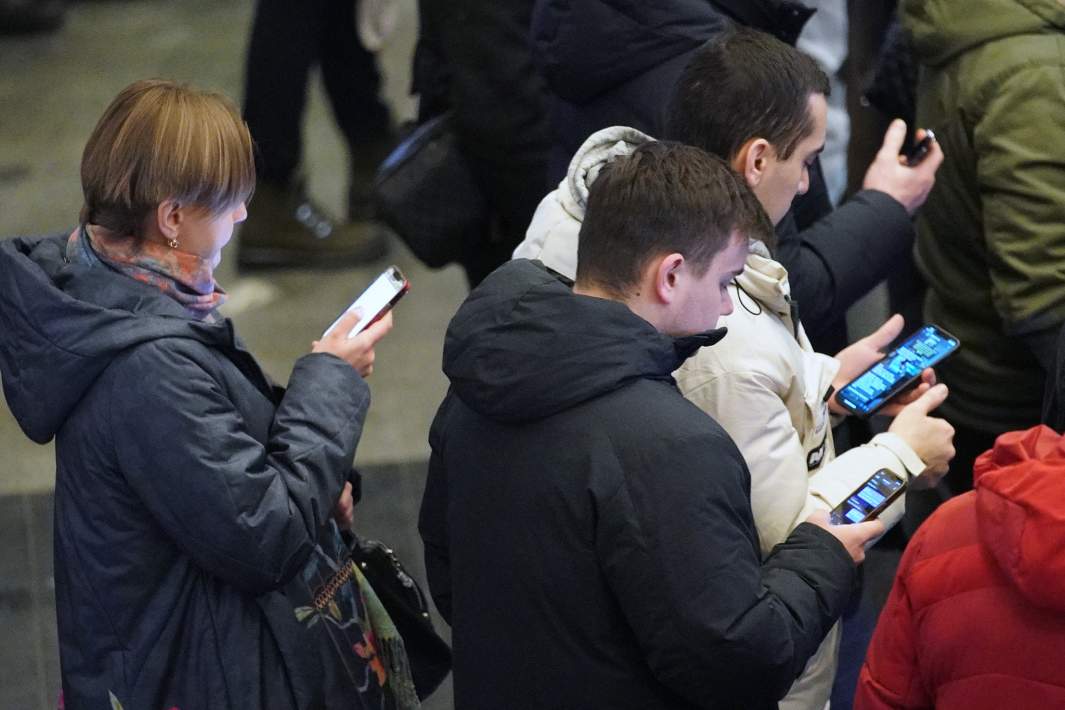 Люди со смартфонами в метро