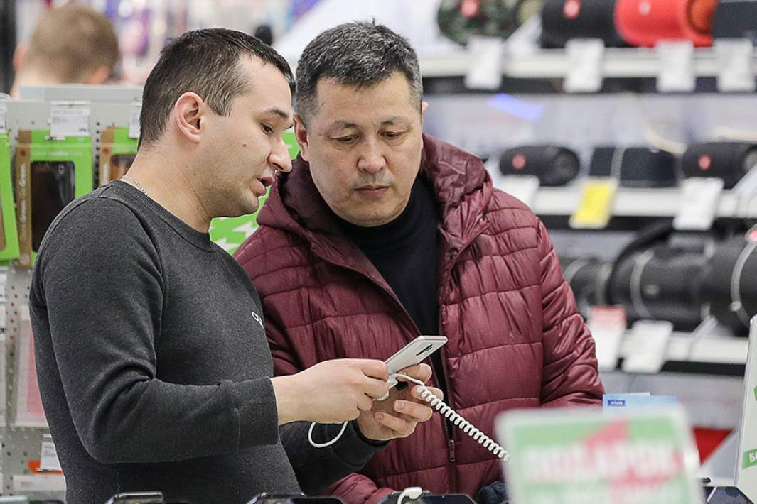 Покупатели рассматривают смартфон в магазине