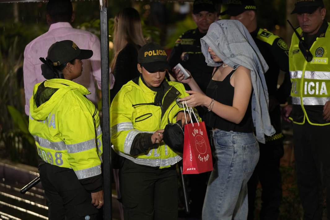 Полиция проверяет возраст женщины во время комендантского часа, который ввели в Медельине для борьбы с сексуальной эксплуатацией несовершеннолетних