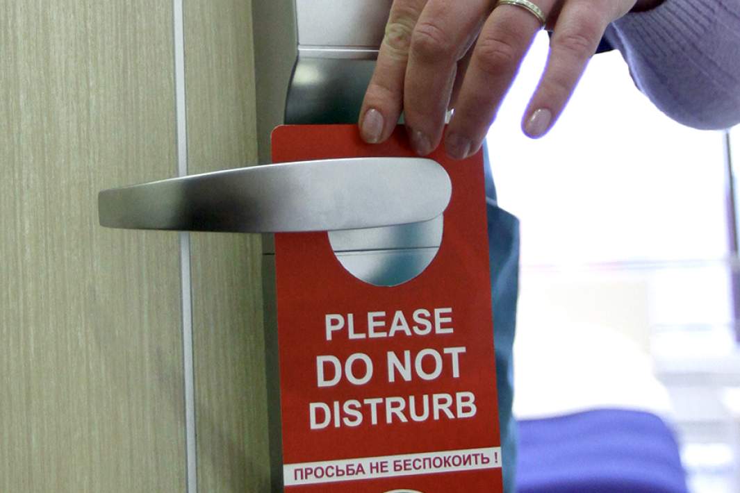 Табличка с надписью «Просьба не беспокоить!» на двери номера отеля